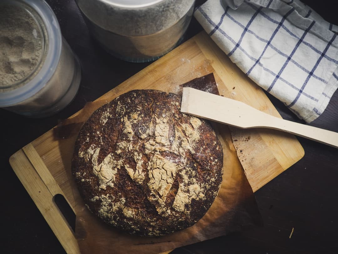 Rustikt mörkbrunt bröd på en träplatta